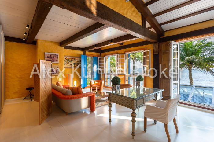 Sala com vigas de madeira e portas para jardim