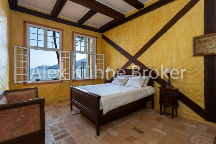 Quarto com paredes amarelas e vigas aparentes