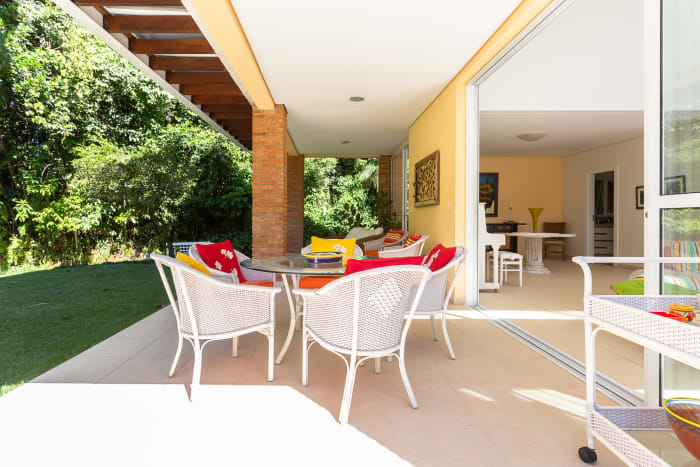 Varanda coberta com área de refeições e jardim