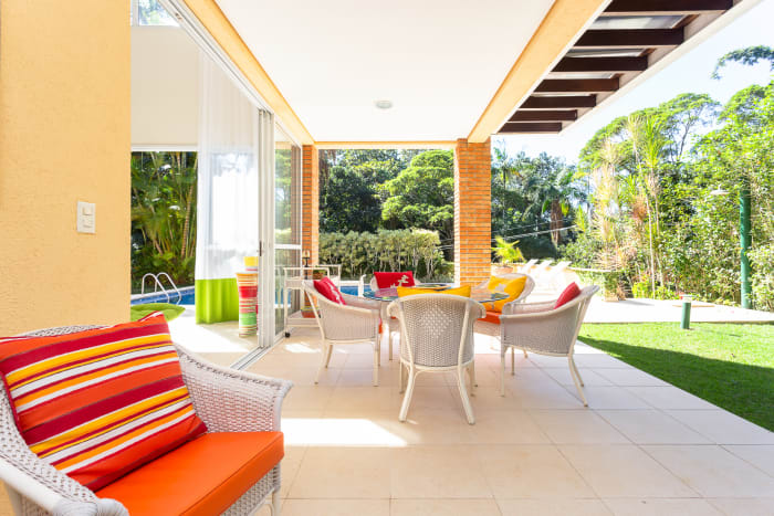 Varanda coberta com ambientes integrados ao jardim