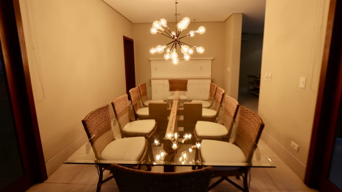 Sala de jantar com lustre moderno e painelamento