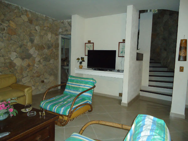 Sala de estar com parede em pedra e escada