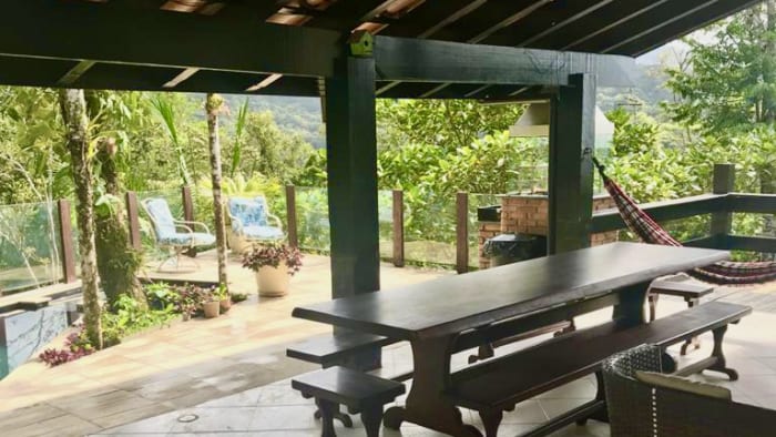 Espaço gourmet com mesa ampla e vegetação