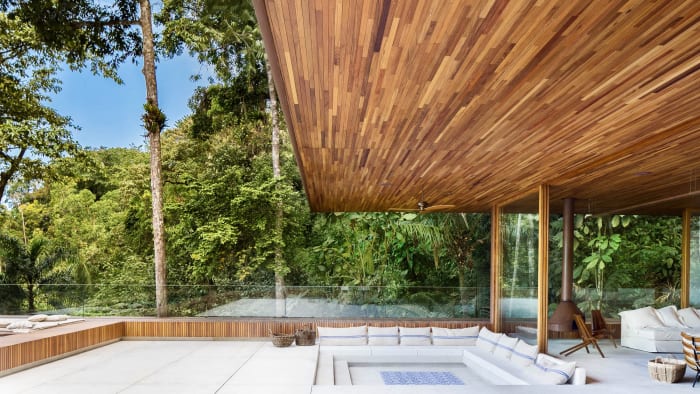 Deck coberto em madeira com piscina e vista mar