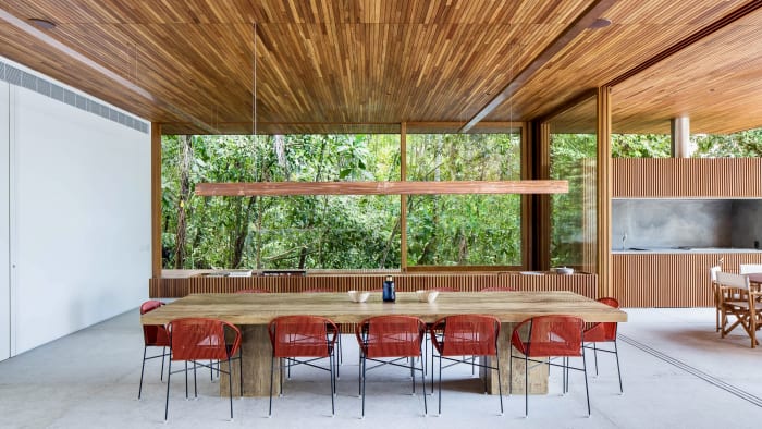 Sala de jantar com mesa de madeira e painéis ripados