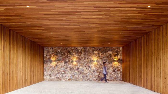 Garagem coberta com revestimento em madeira e pedra