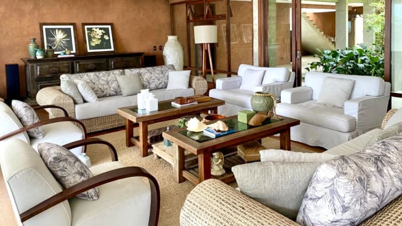 Sala de estar com móveis claros e parede texturizada