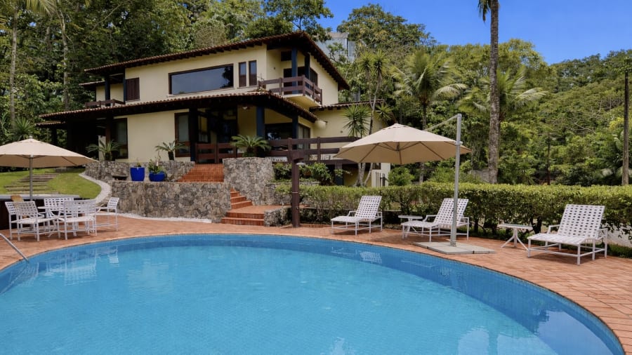 Casa à venda no Condomínio Iporanga, Guarujá, com amplo terreno e alto potencial de retrofit, a 150 metros da Praia de São Pedro.