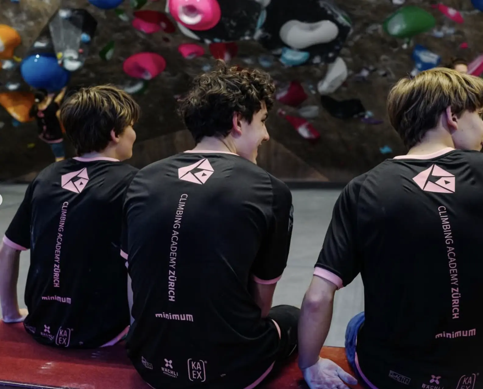 Climbing Academy Zürich athletes seated from behind showing screen printed back of competition kit