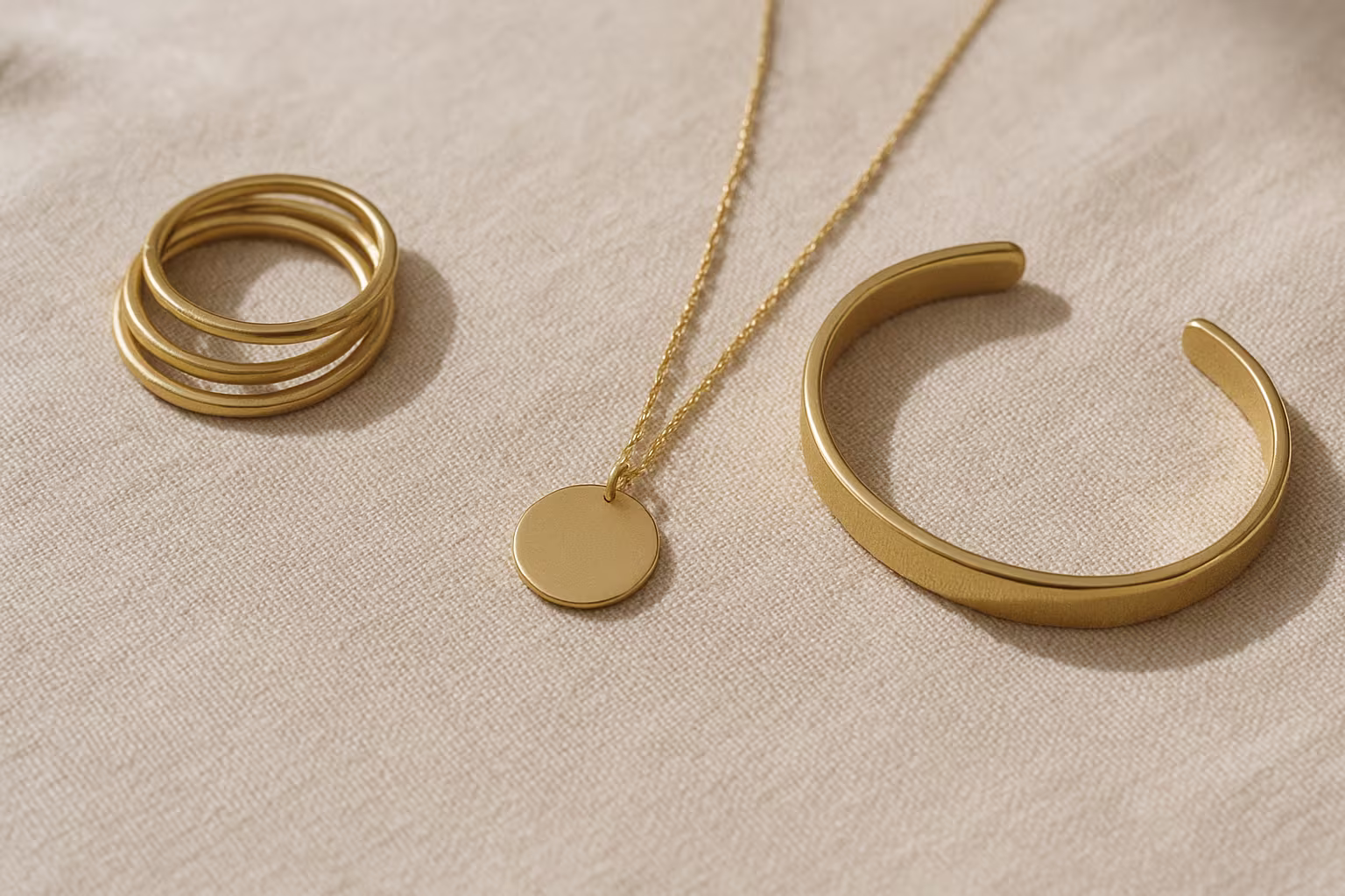 Close display of multiple jewelry types on neutral fabric, editorial photo focusing on textures