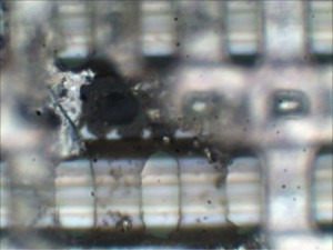 Higher magnification revealing deformed glass and metal