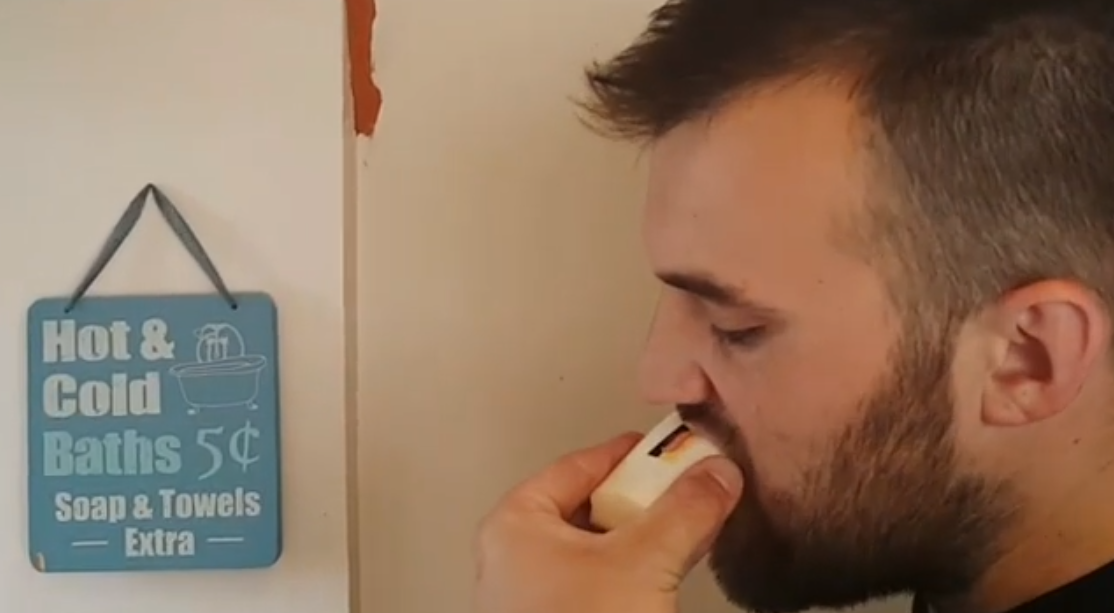 Man with a beard eating a bar of soap that is actually made of food, optical illusion by chefbenchurchill instagram