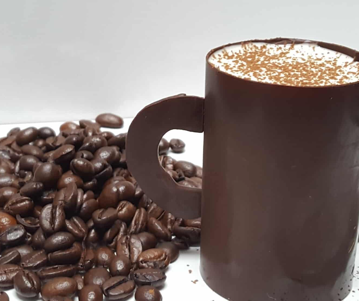 Cup of coffee made of chocolate next to a pile of coffee beans, chefbenchurchill instagram