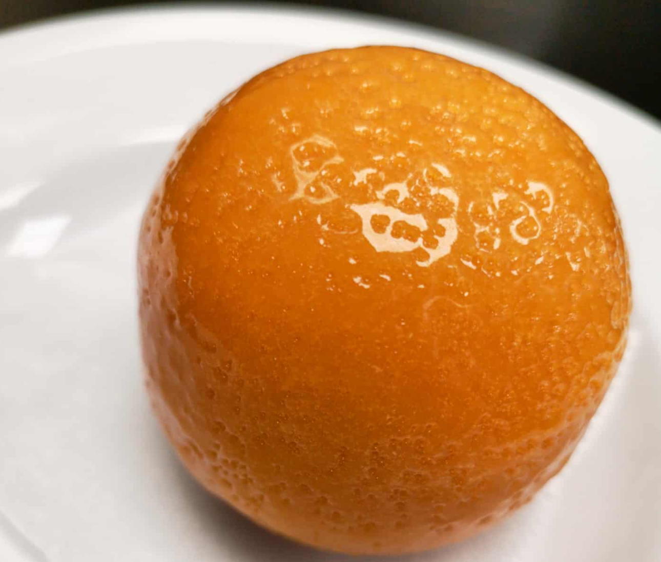 Glistening orange on a white plate, made of candy and cake, chefbenchurchill instagram