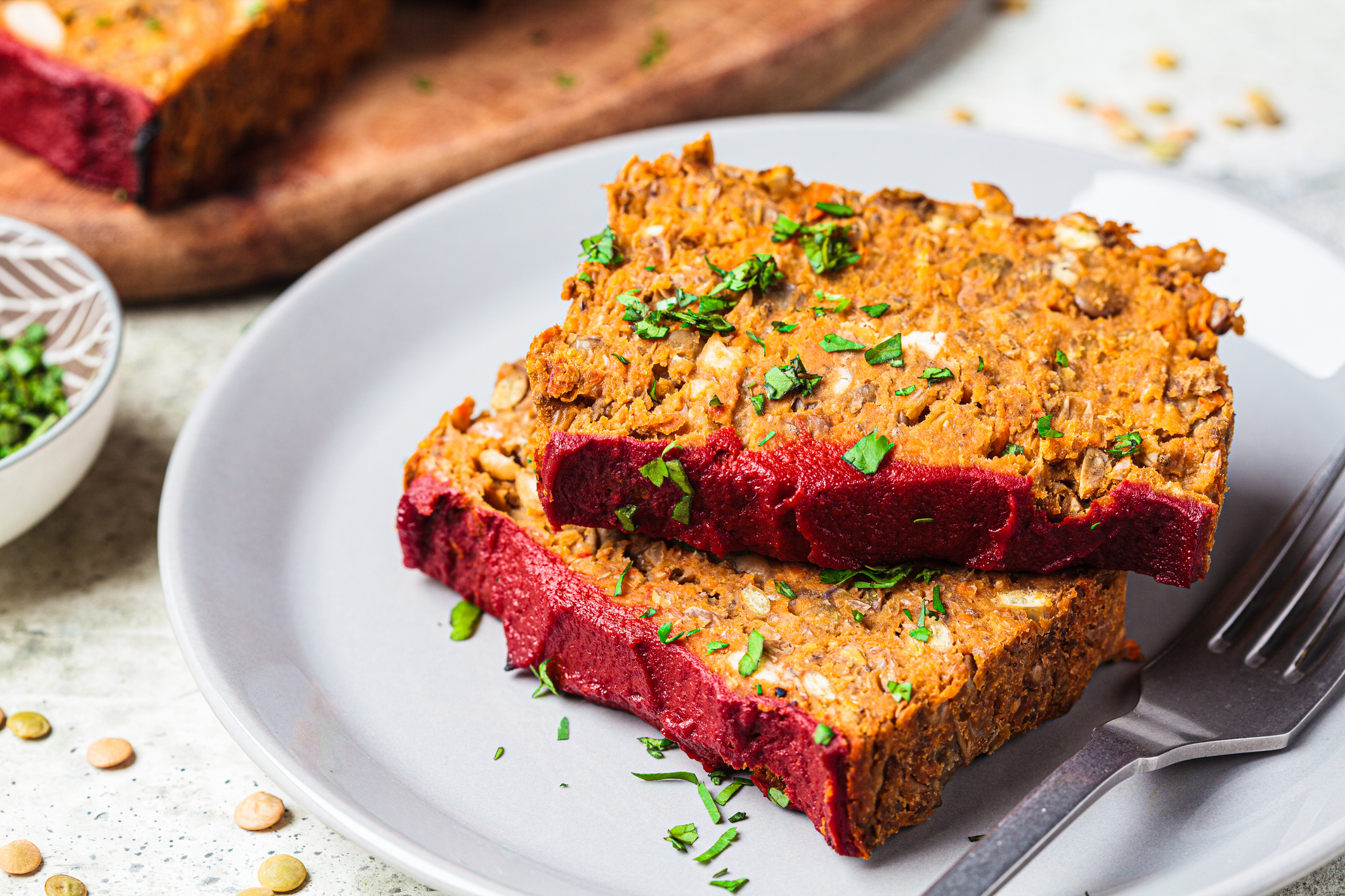 Lentil vegan meatloaf slices on a gray plate, close-up. Christmas plant-based recipe.