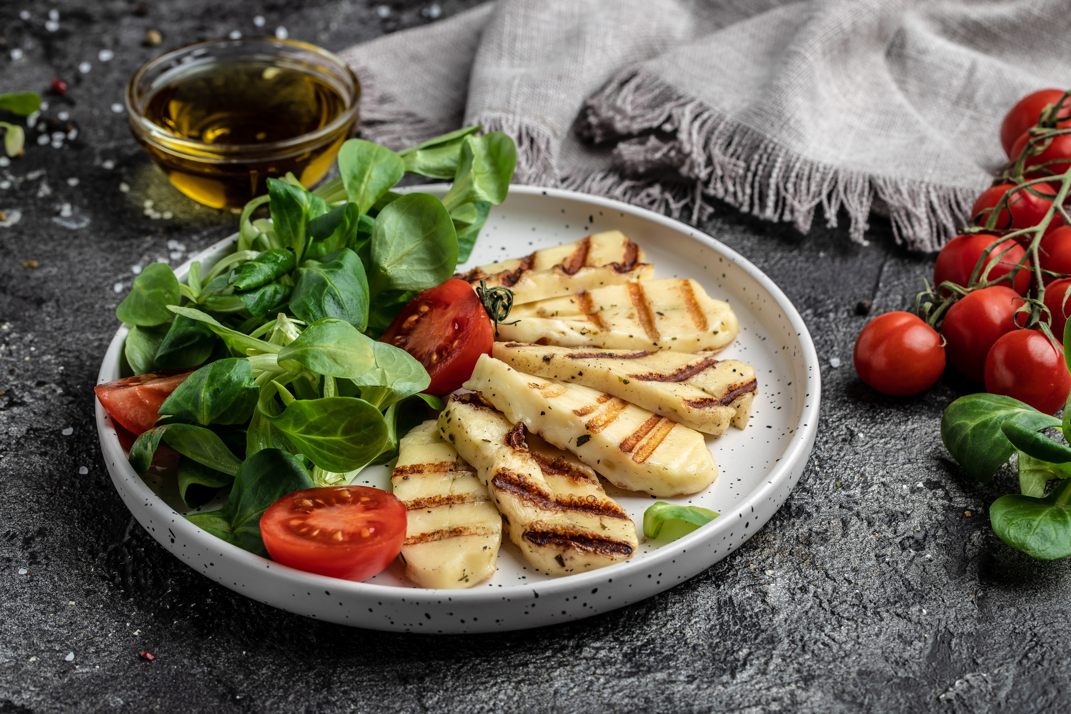 halloumi cheese with mint. alad with grilled halloumi cheese, tomatoes, capers, lettuce and arugula, Cyprus squeaky cheese. top view.