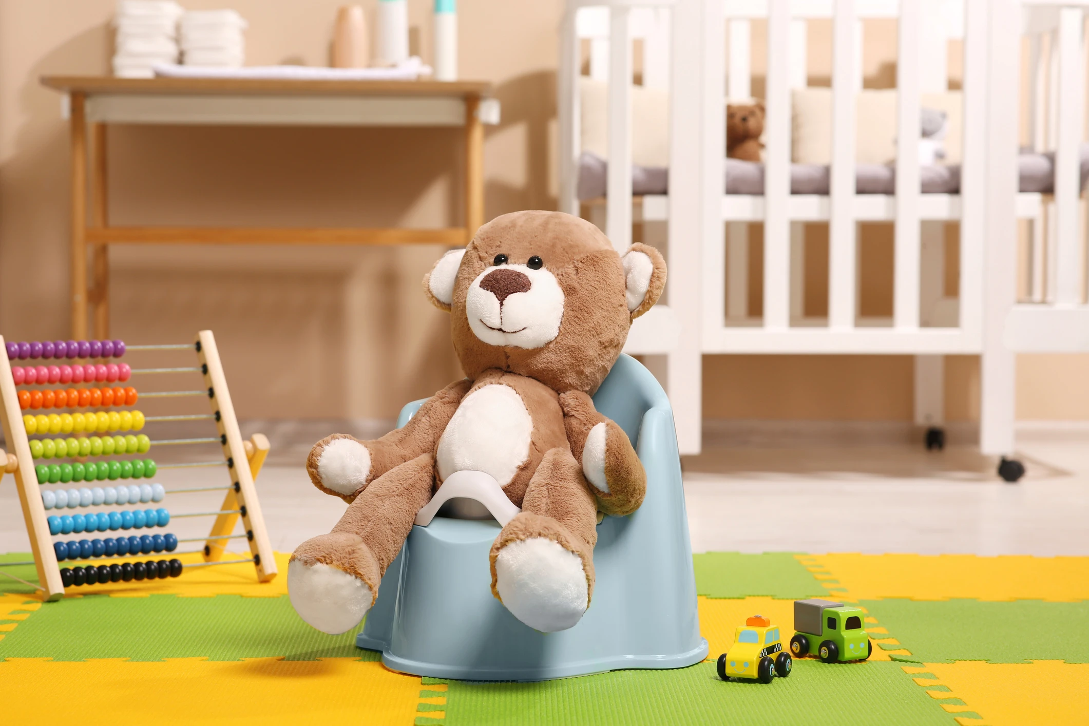 Cute teddy bear on light blue baby potty in room. Toilet training