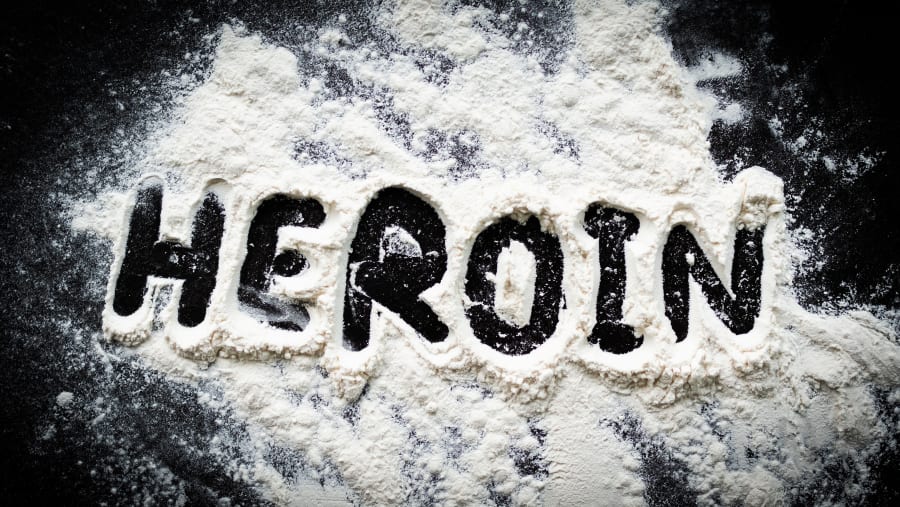powder heroin on dark black table background.
