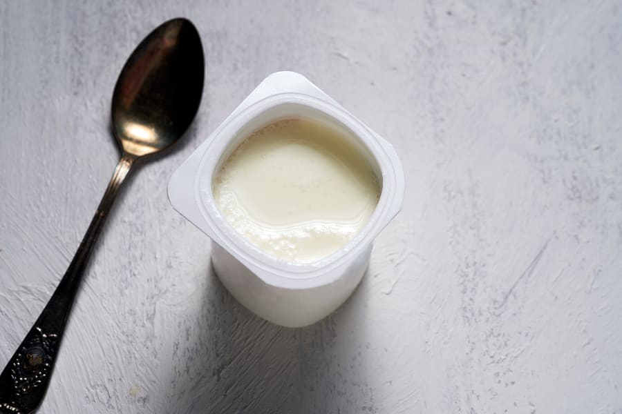 Yogurt in container on a wooden table