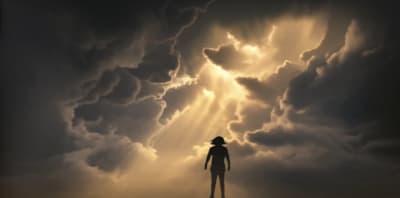 Person standing strong against a storm, symbolizing resilience