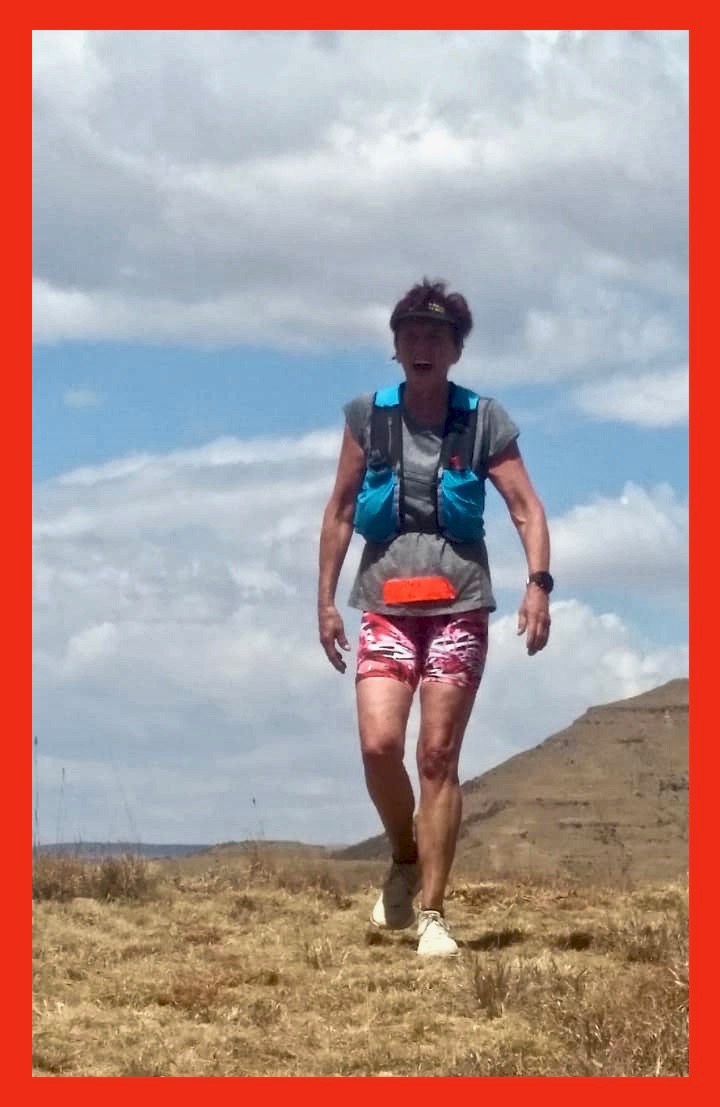 runner on a graasy peak in the lower Southern Drakensberg