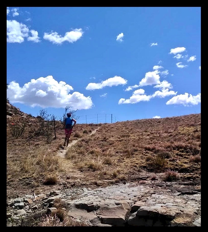 lady running up a rural mountain path