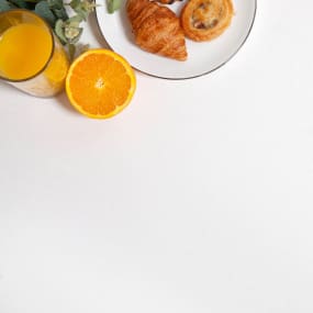 Alpine Solid Surface With Fresh orange juice, orange and pastries on plate