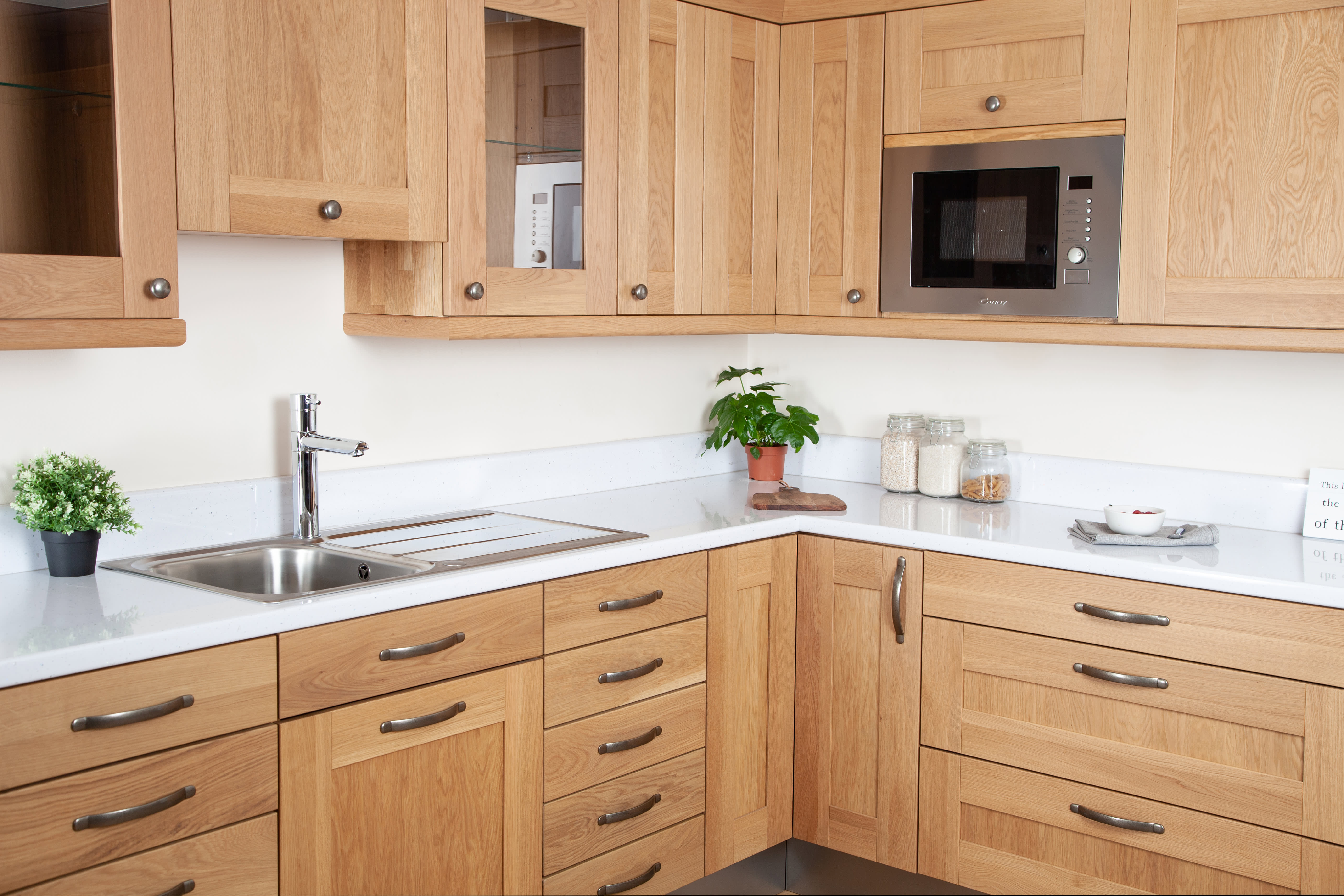 White Sparkle Kitchen Worktop in oak kitchen with potted plants and a stainless steel sink