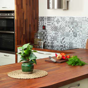 Black American Walnut wooden worktop in Kitchen with plant and chopping board on surface