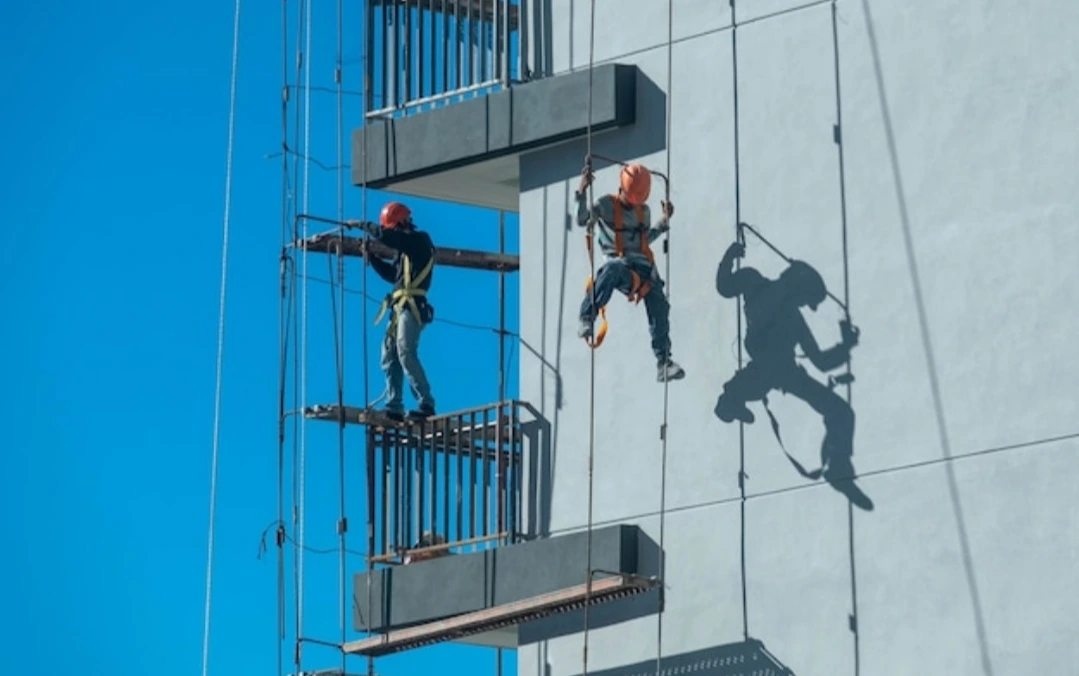 Trabajadores con equipo de protección (EPI) realizando tareas en una zona de riesgo.