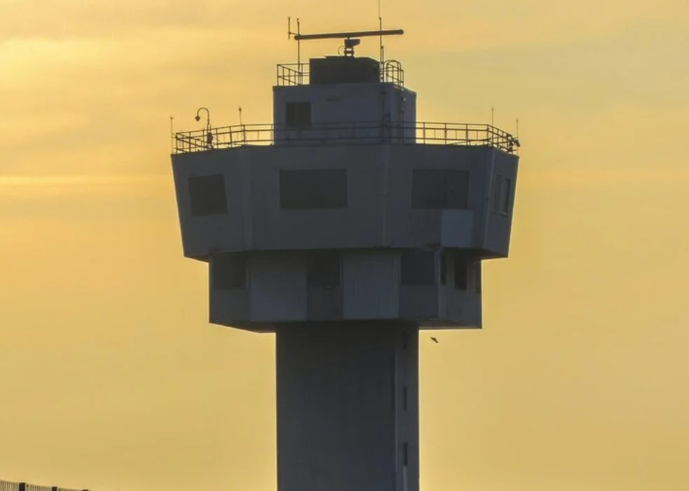 Torre de control de tráfico aéreo fotografiada al atardecer con cielo dorado, representando la huelga indefinida de controladores en los aeropuertos gestionados por Saerco desde el 17 de abril de 2026