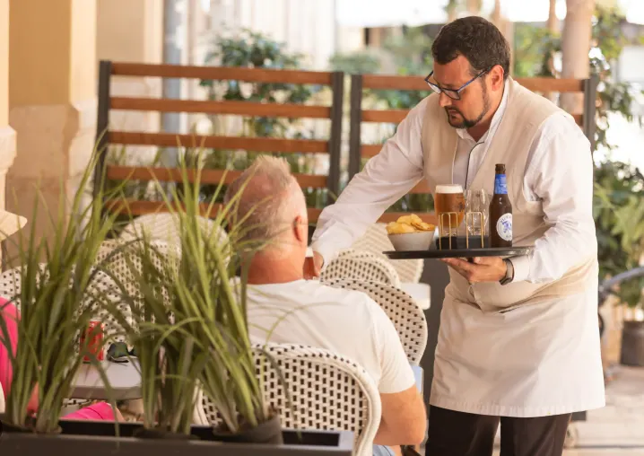 Camarero sirviendo bebidas, sector servicios en aumento
