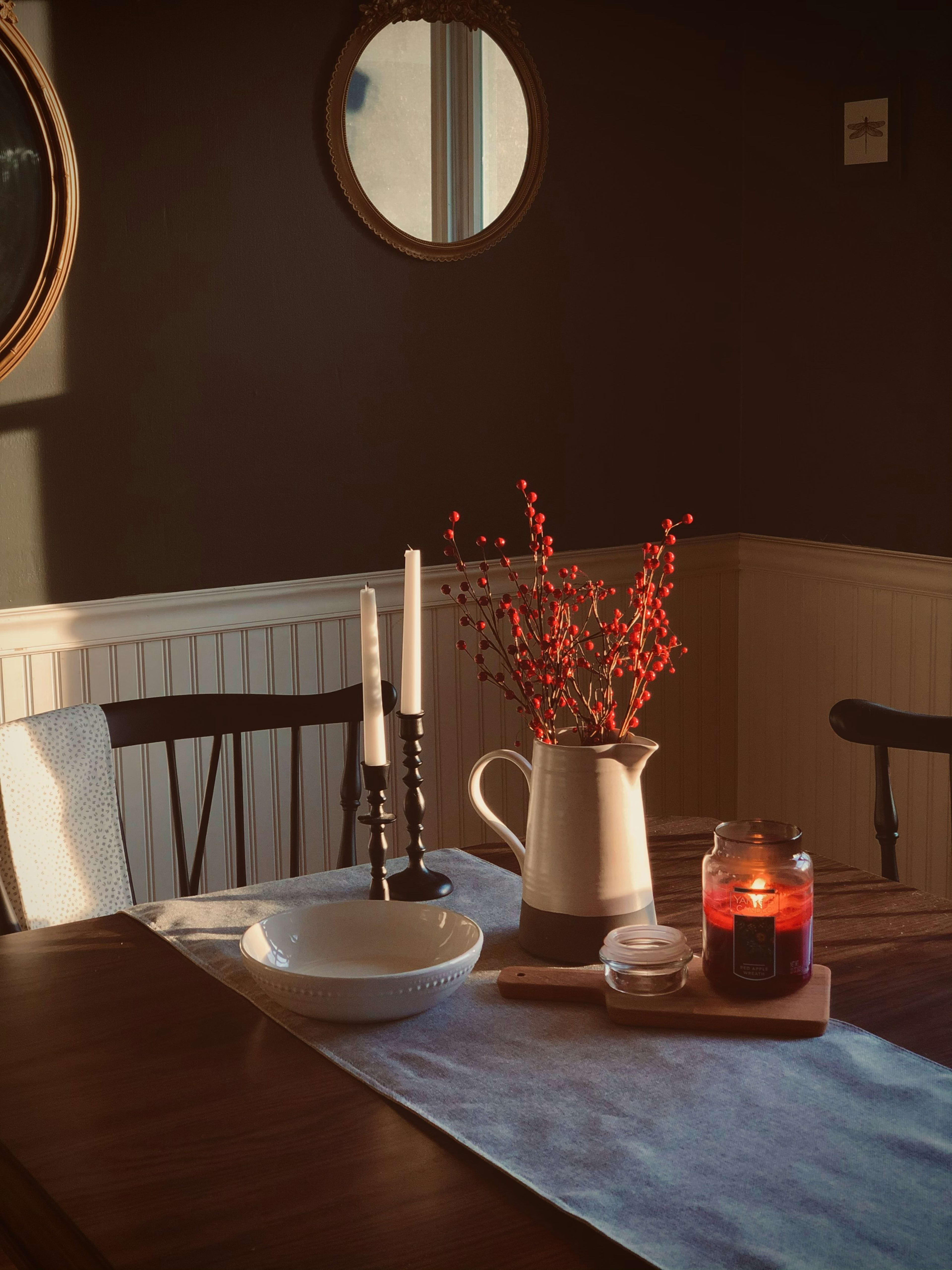 Candles and red berries on a dining table