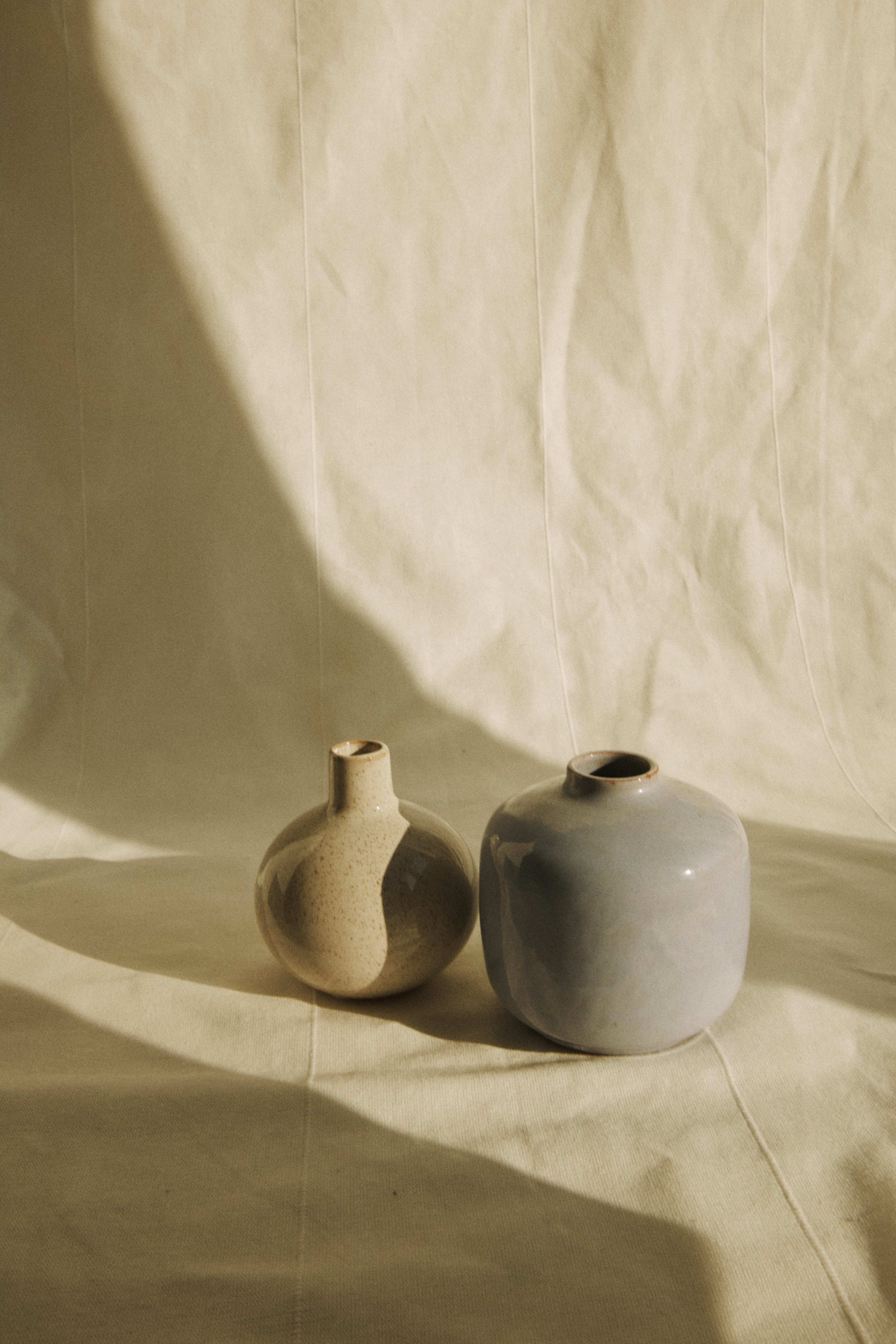 Handmade clay vases on draped linen