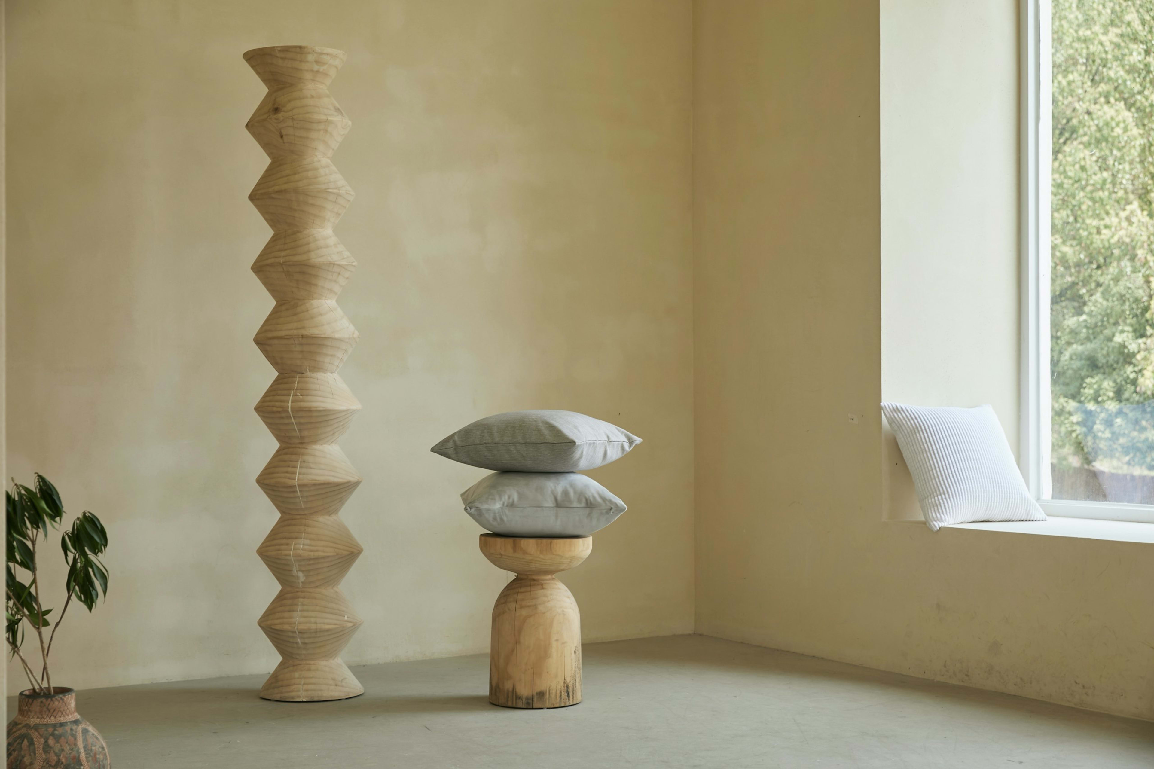 A sculptural wooden column in a sunlit room