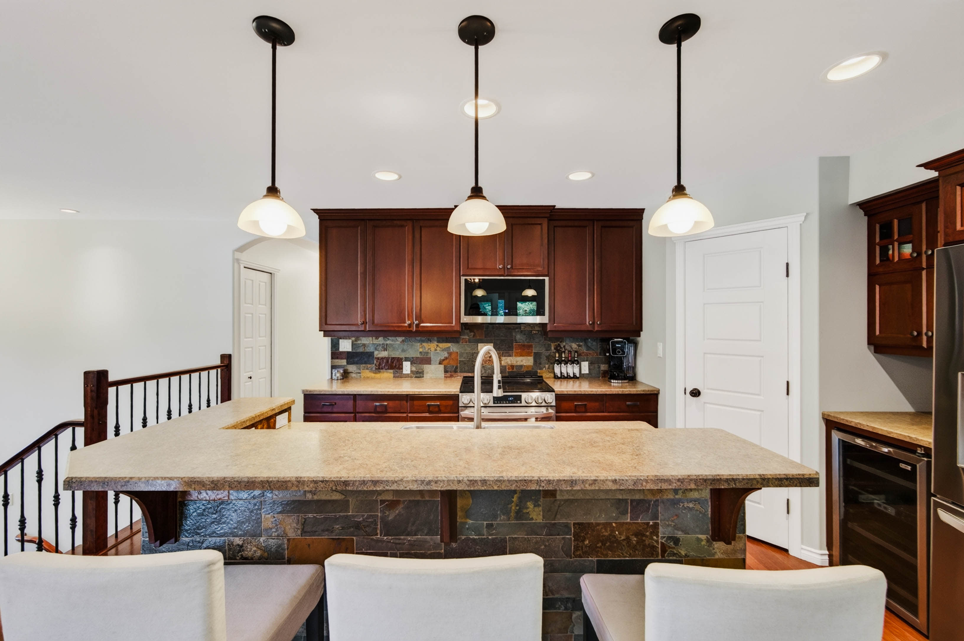 Generous kitchen with stone-topped island and wood cabinetry