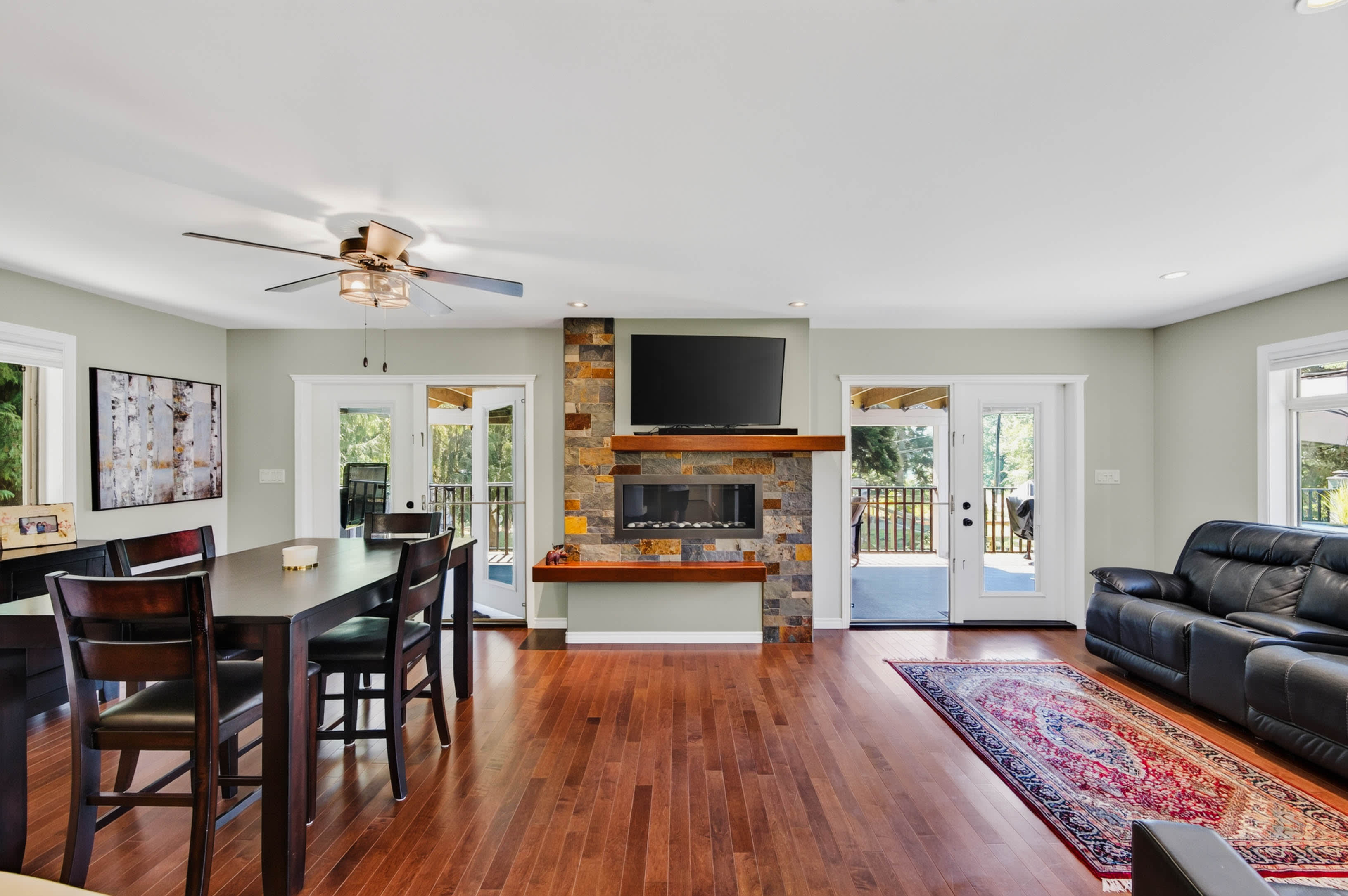 Open-concept living and dining room with stone fireplace
