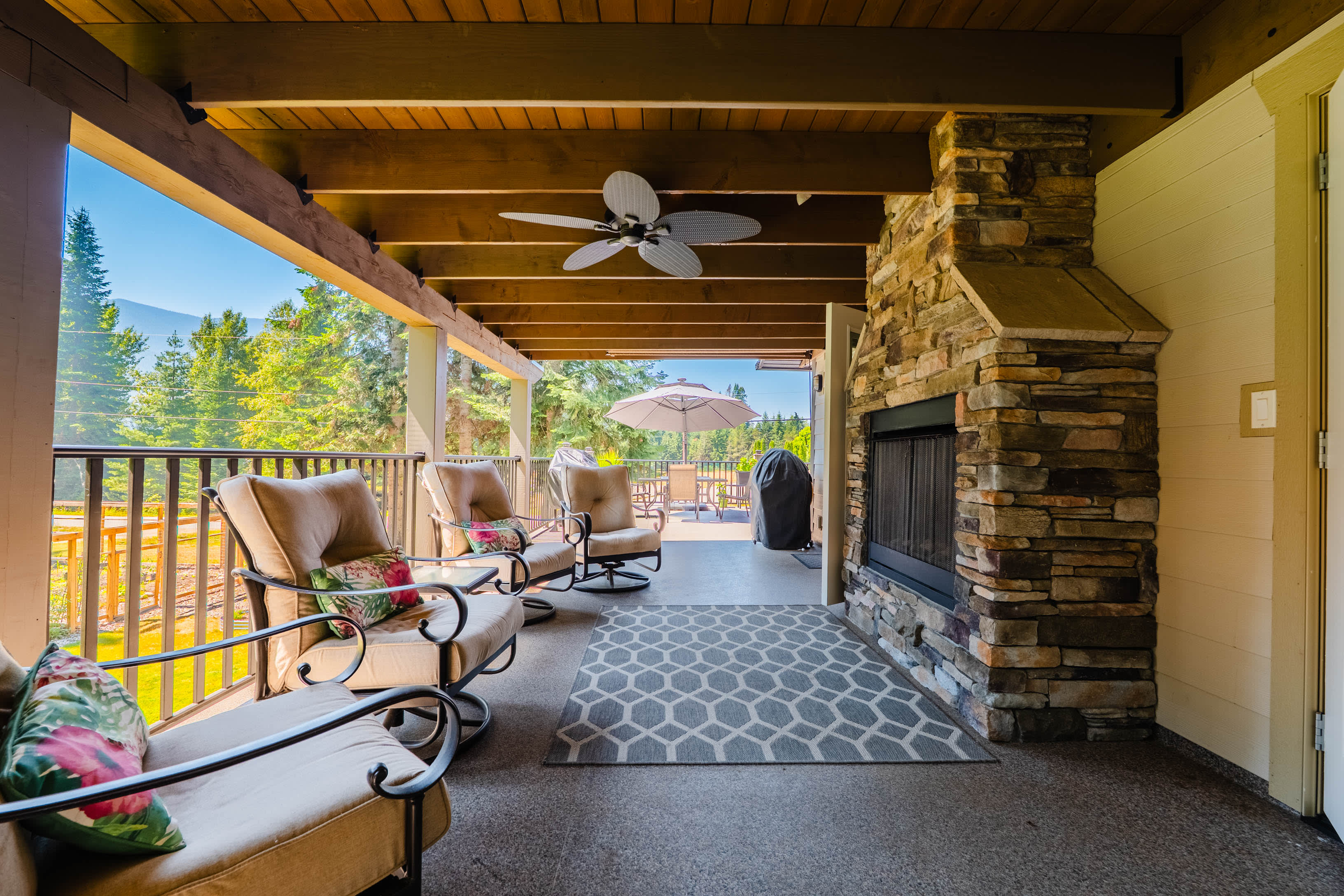 Covered outdoor living room with stone fireplace