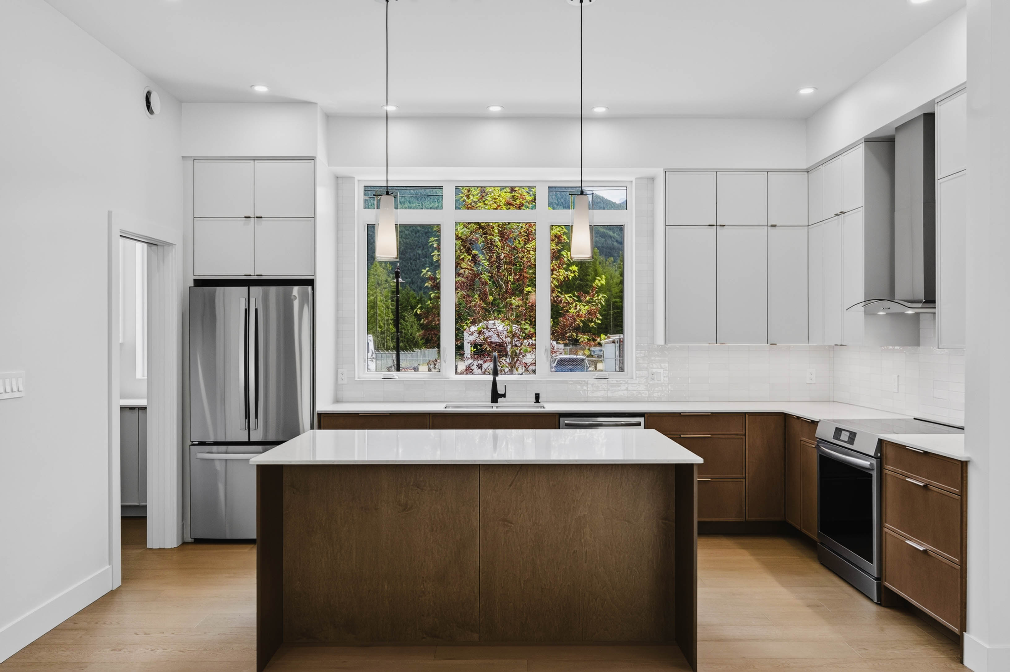 Modern kitchen at 7769 Holt Road with island, warm wood cabinetry, and bright finishes