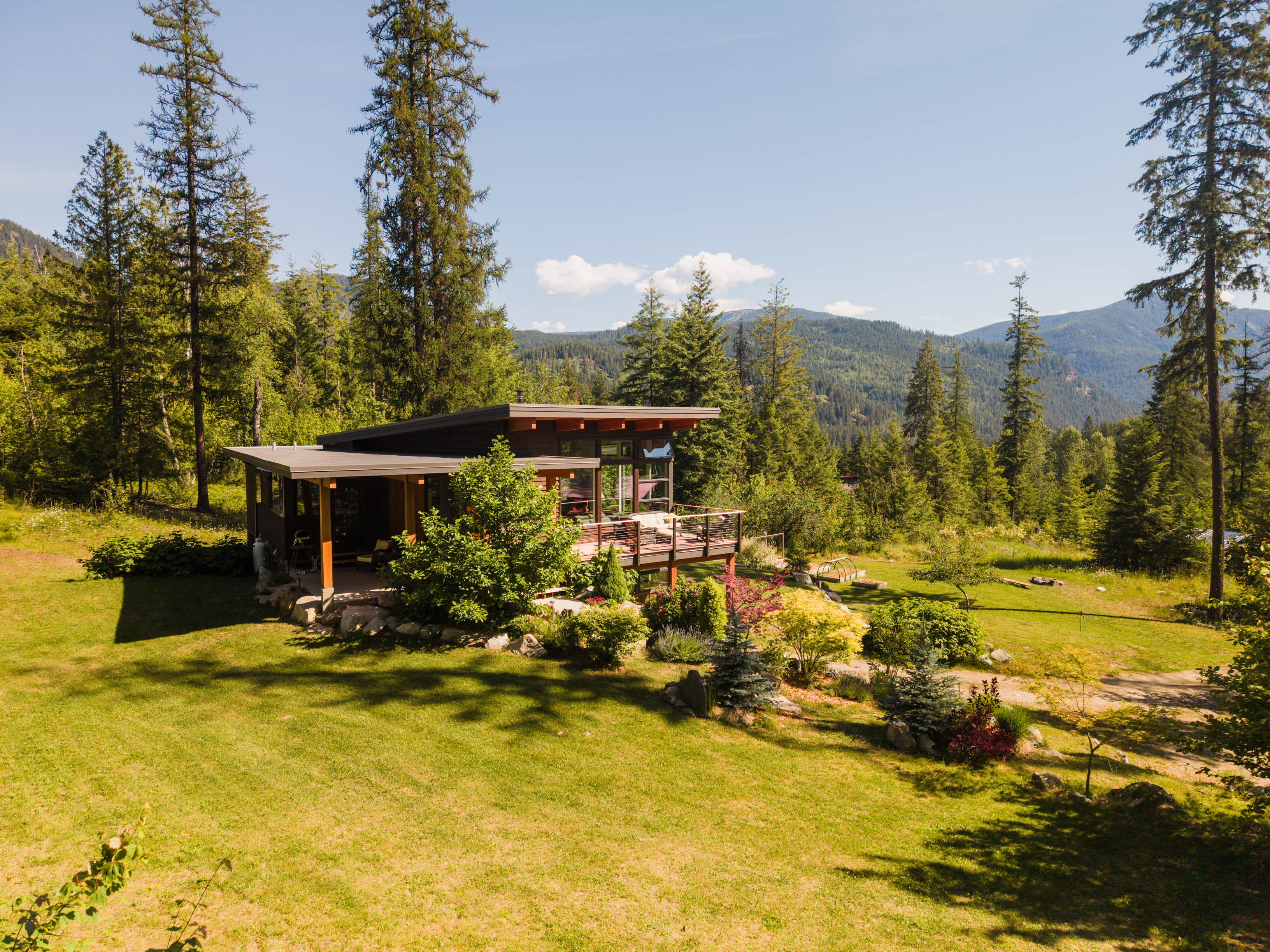 Exterior of 4135 Kays Road with deck, gardens, and mountain setting