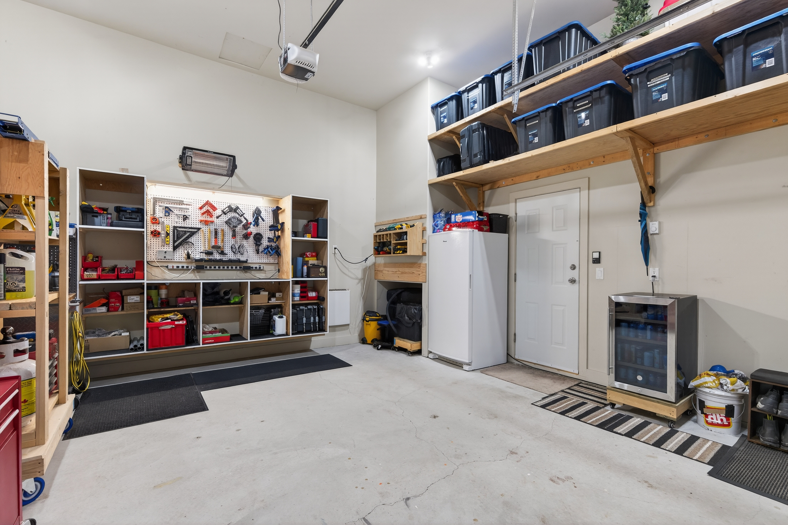 Attached garage with high ceiling, shelving and workspace