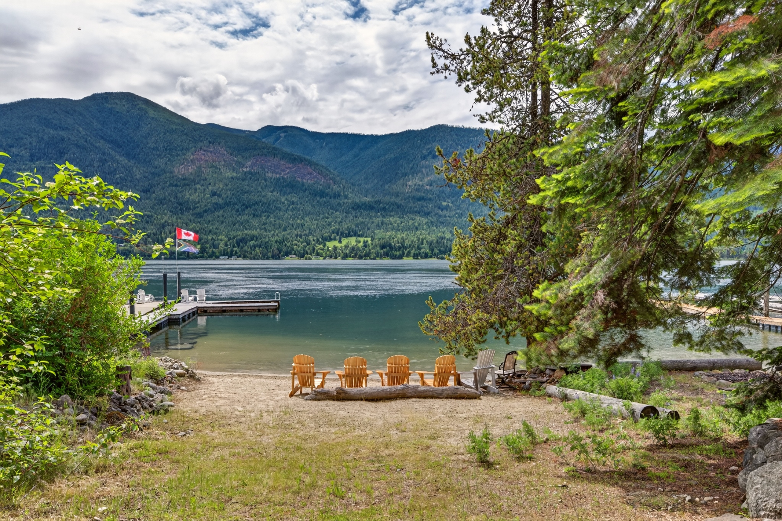 Sandy shoreline, Adirondack chairs and private dock at 6506 Littlewood Road