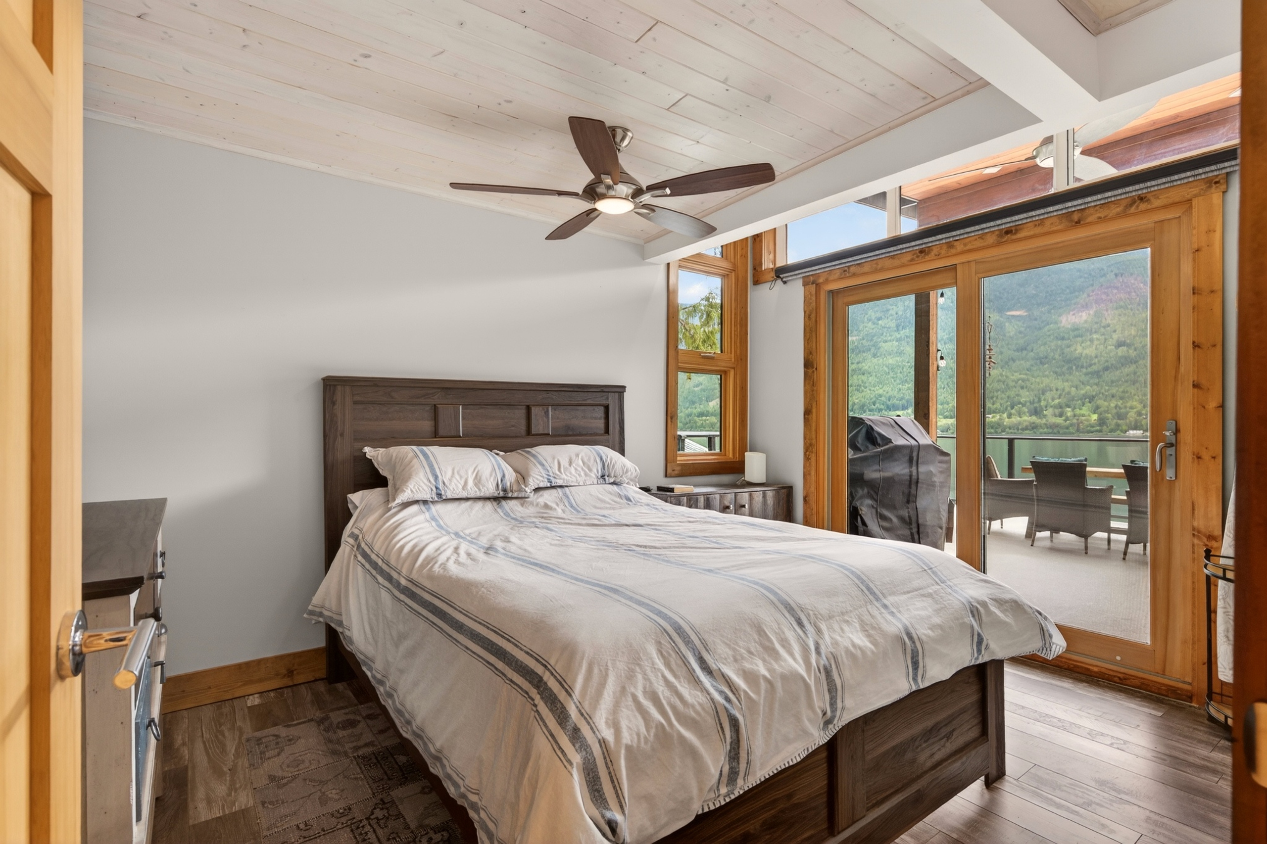 Primary bedroom with direct access to the lake-facing deck