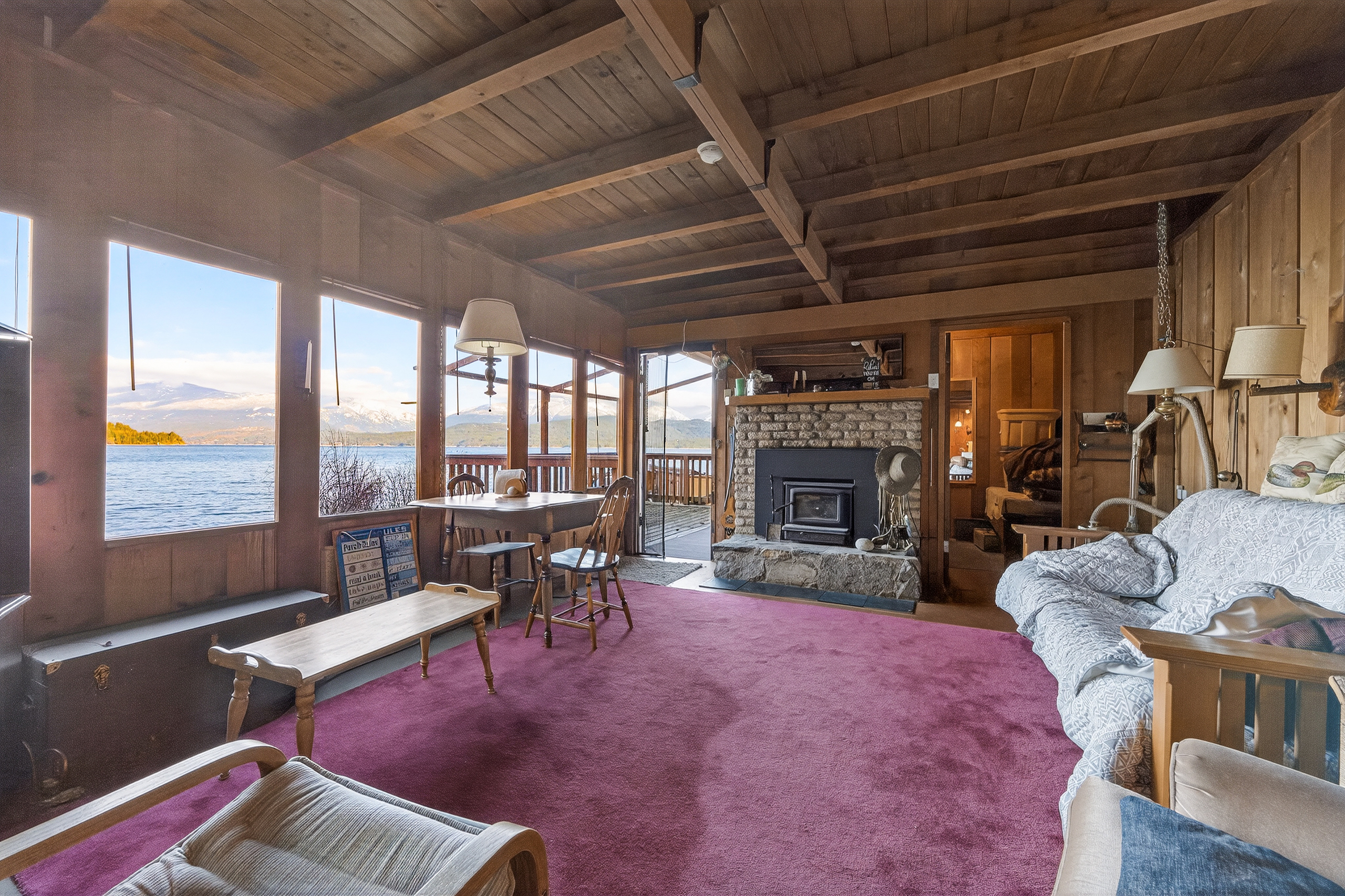 Wood-lined living room with fireplace and views over Kootenay Lake