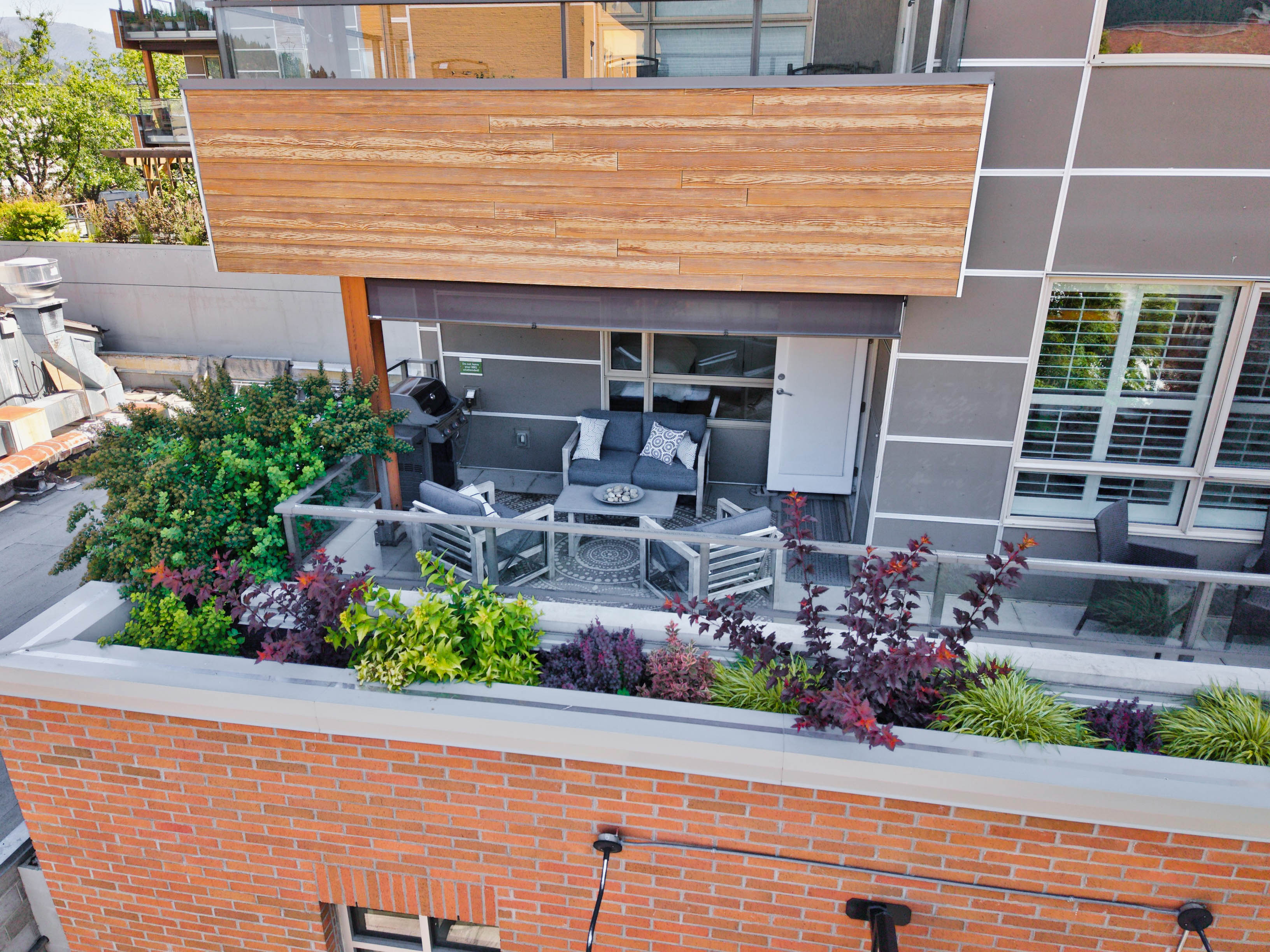 Private covered deck and landscaped exterior at 215–710 Vernon Street
