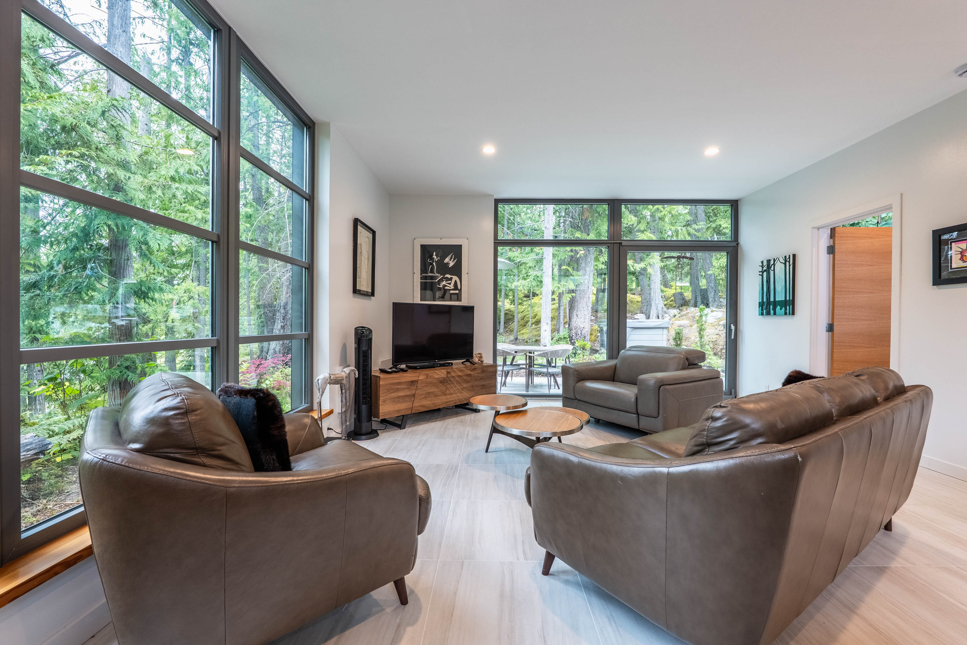 Bright contemporary living room with floor-to-ceiling forest views