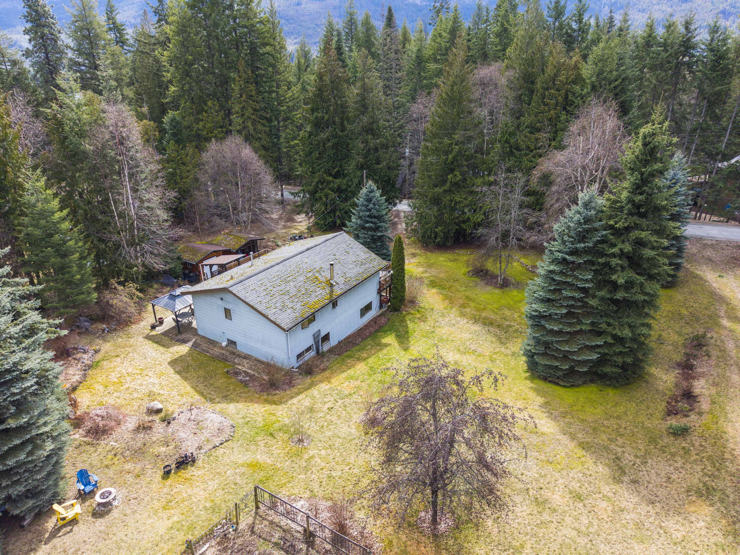Aerial view of the home, gardens and mature-tree setting at 7077 Beggs Road