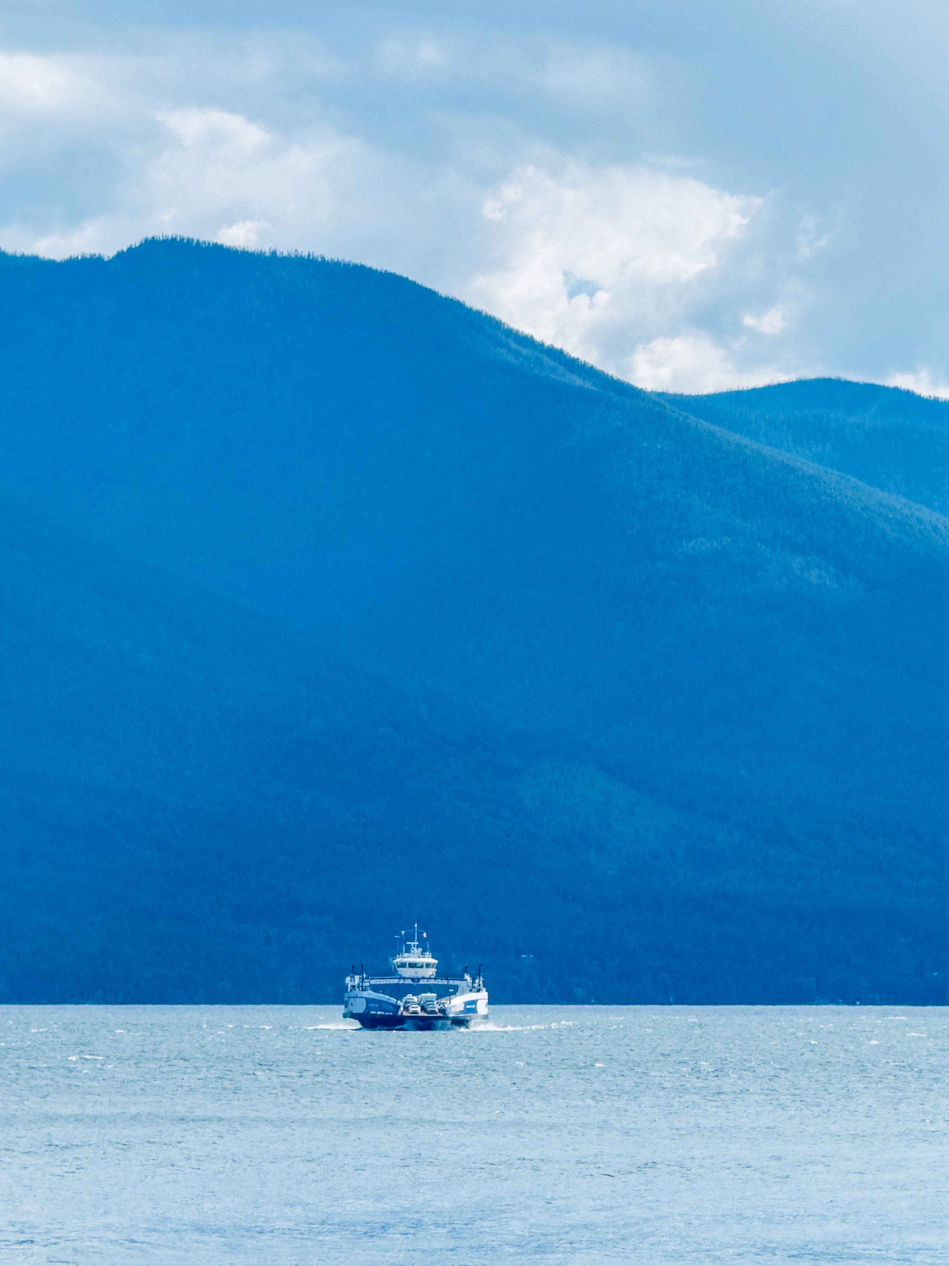 Kootenay Lake Ferry travelling beneath mountain scenery