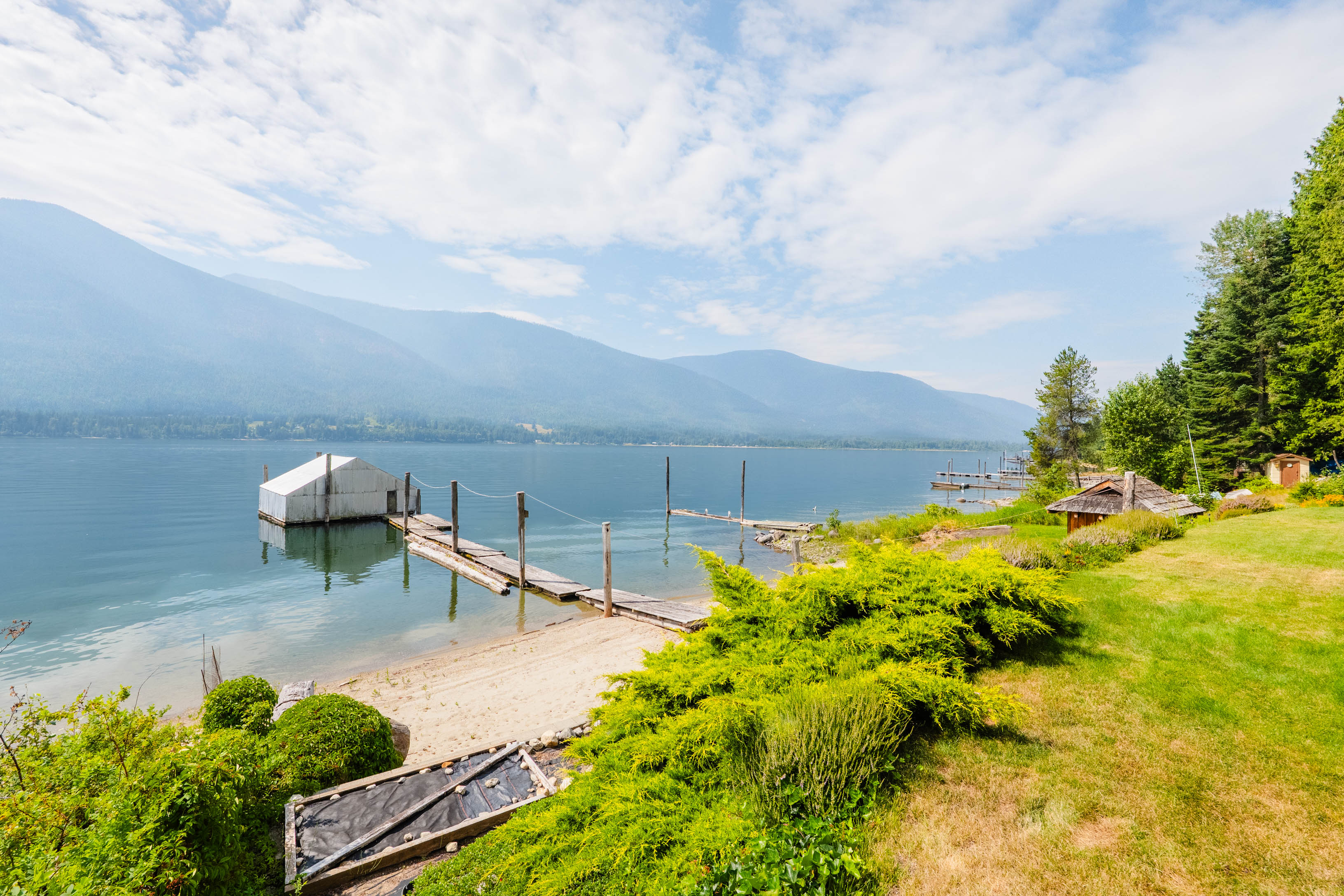 Sandy beach and dock on Kootenay Lake