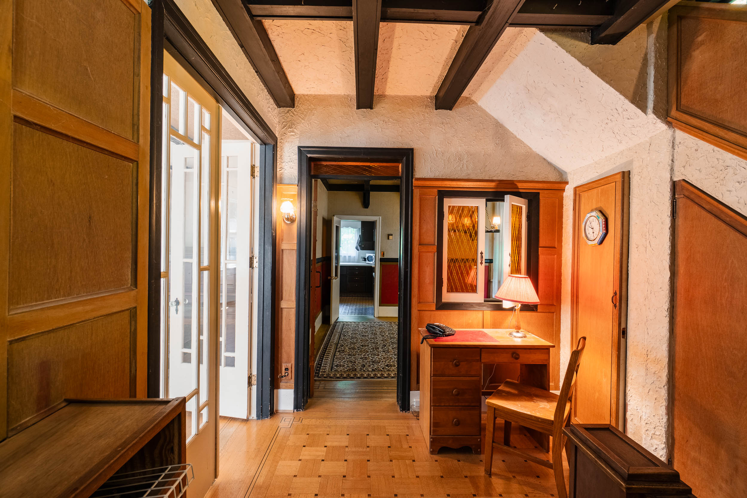Ceiling beams, French doors, detailed wood trim and built-in desk